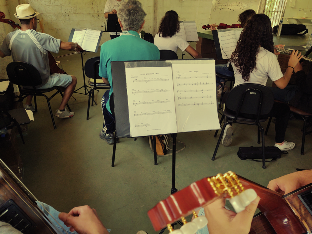 pauta musical com musicos de orquestra ao fundo